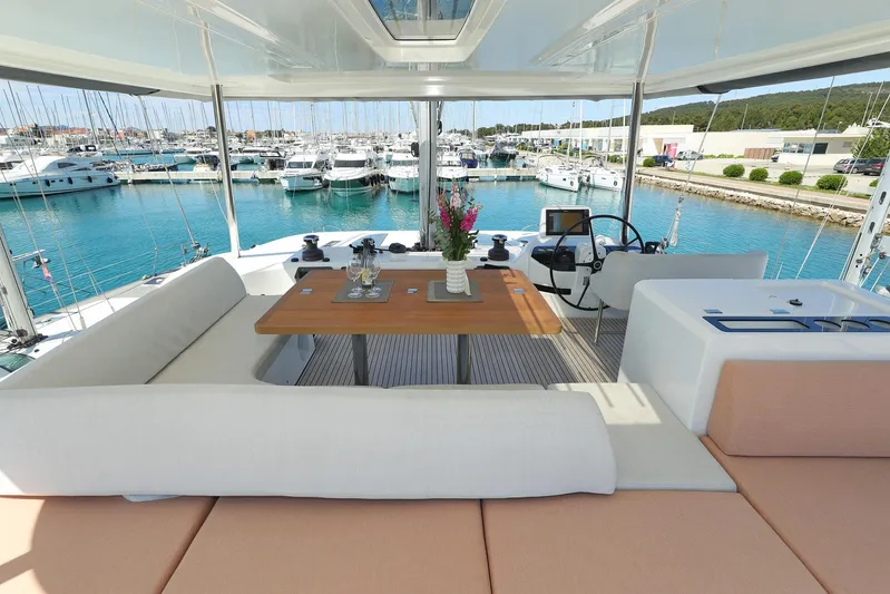 Saliska Yacht Photos Pics Luxurious Lagoon 55 yacht interior with elegant seating and dining area, overlooking a serene marina.