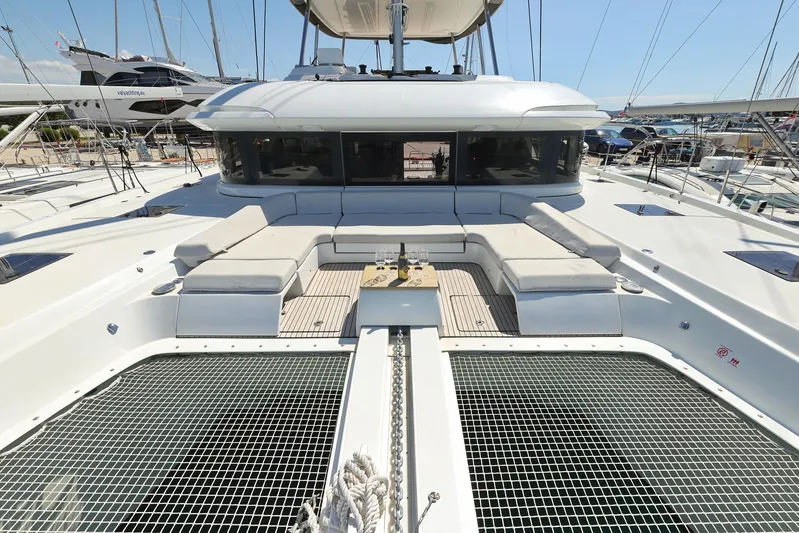 Saliska Yacht Photos Pics 2023 Lagoon 55 yacht deck with seating and netting, showcasing luxury and modern design.