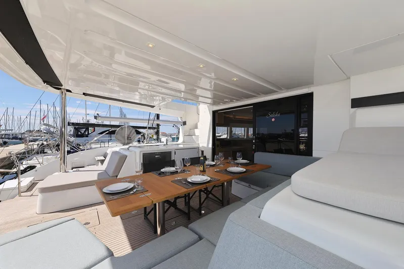 Saliska Yacht Photos Pics Luxurious 2023 Lagoon 55 yacht with elegant outdoor dining area and marina view.