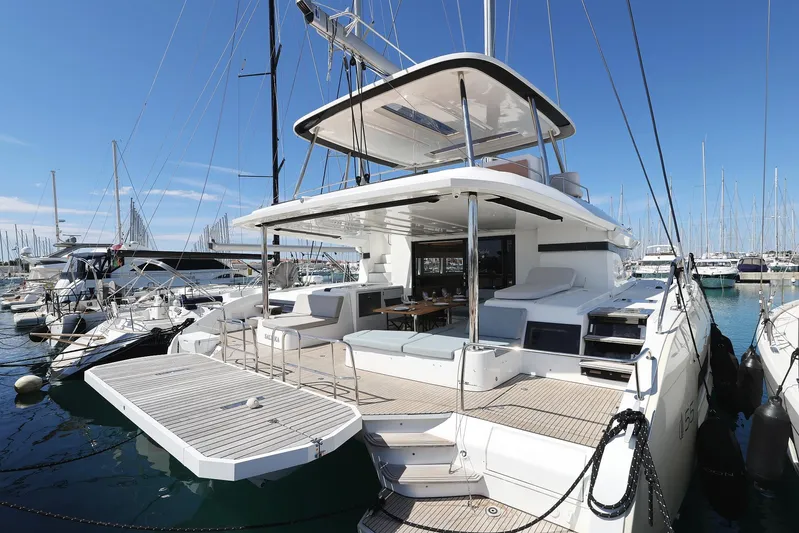 Saliska Yacht Photos Pics 2023 Lagoon 55 yacht docked in marina, featuring spacious deck and modern design.