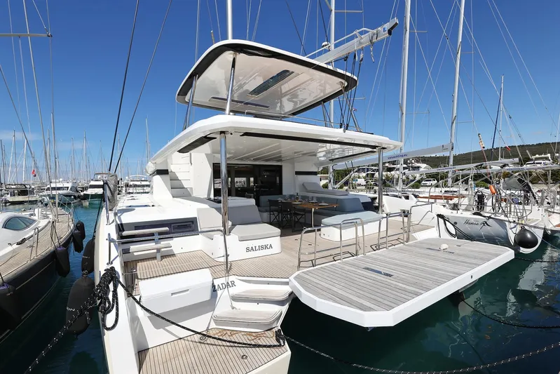 Saliska Yacht Photos Pics 2023 Lagoon 55 yacht docked in marina, showcasing spacious deck and modern design.