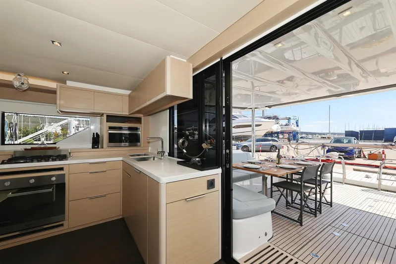 Saliska Yacht Photos Pics Modern kitchen and dining area on 2023 Lagoon 55 yacht, featuring sleek design and marina view.