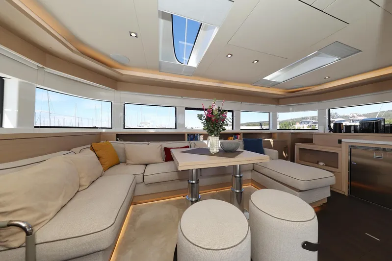 Saliska Yacht Photos Pics Luxurious interior of 2023 Lagoon 55 yacht with modern seating and panoramic windows.