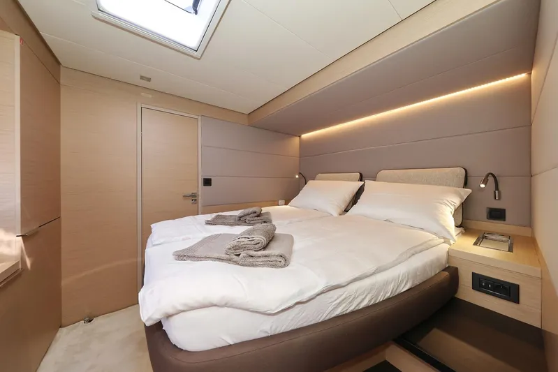 Saliska Yacht Photos Pics Luxurious bedroom interior of 2023 Lagoon 55 yacht with modern design and cozy bedding.