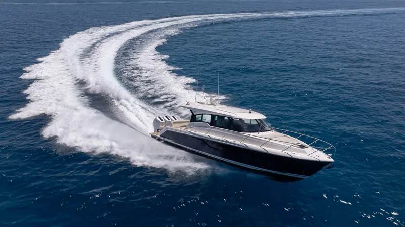  Yacht Photos Pics 2024 Tiara Yachts 48 LE cruising on open water, creating a dynamic wake.