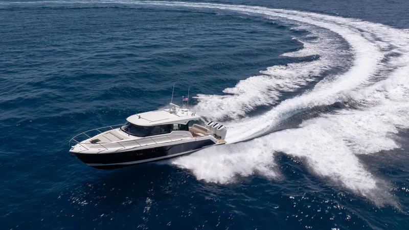  Yacht Photos Pics 2024 Tiara Yachts 48 LE cruising on open ocean, creating dynamic water trails.