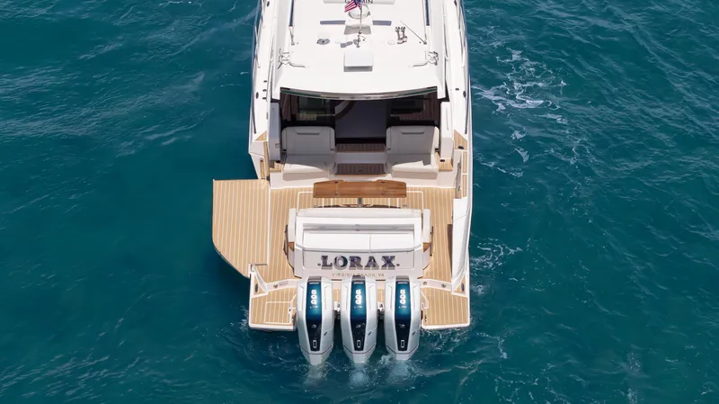  Yacht Photos Pics 2024 Tiara Yachts 48 LE with triple outboard engines on blue ocean water.