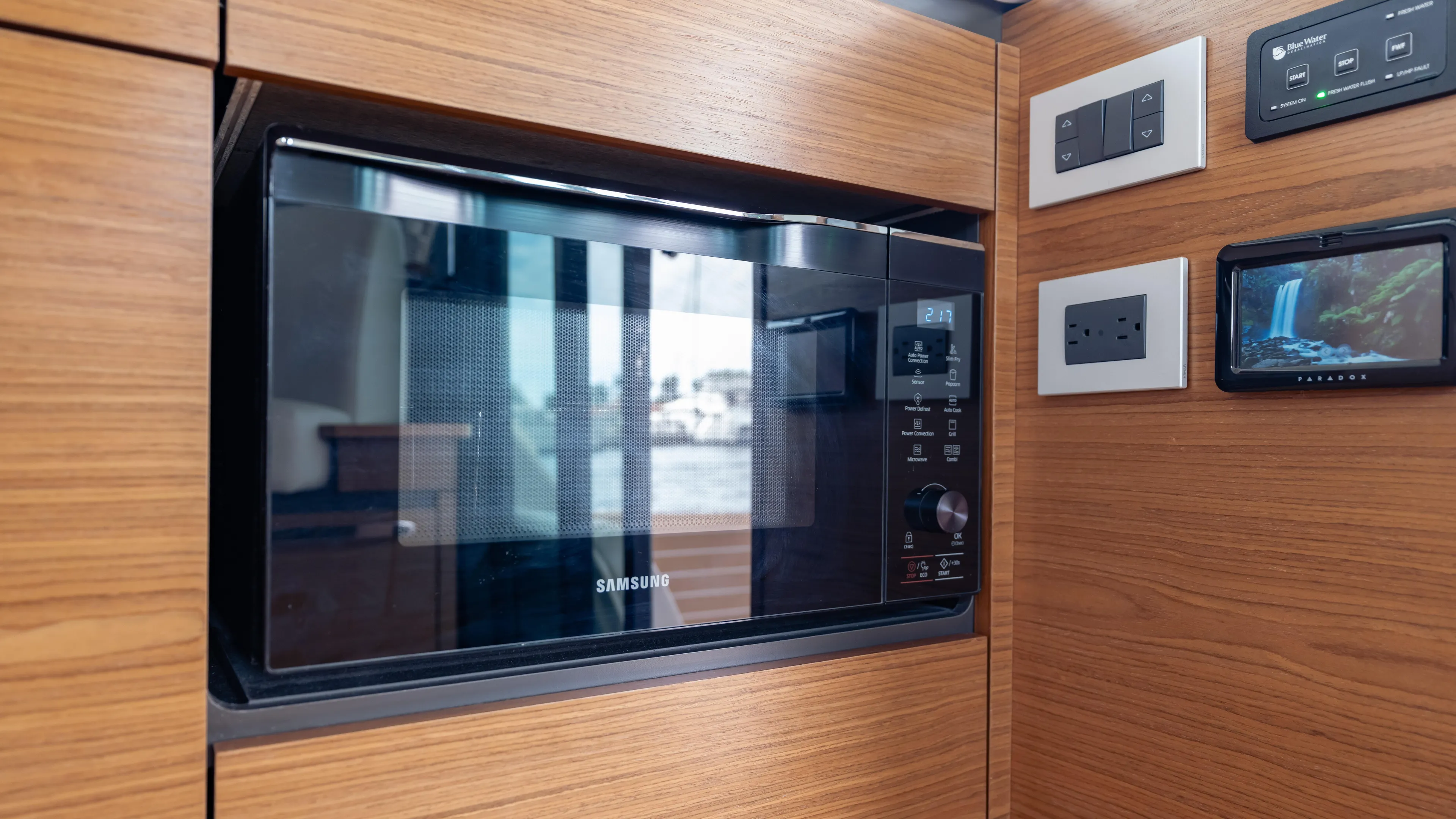  Yacht Photos Pics Microwave in 2024 Tiara Yachts 48 LE, surrounded by wooden cabinetry and control panels.