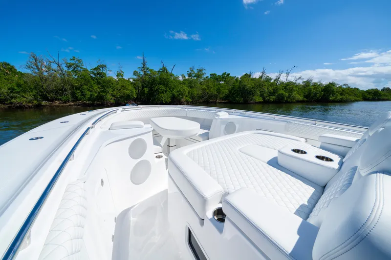  Yacht Photos Pics Luxurious 2026 HCB 48 Campeon boat interior with white seating, cruising on a sunny day.