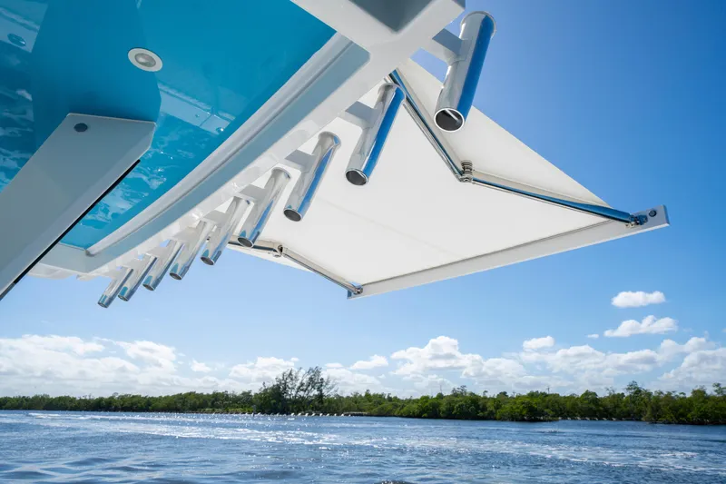  Yacht Photos Pics 2026 HCB 48 Campeon boat with rod holders and awning, cruising on a sunny day.