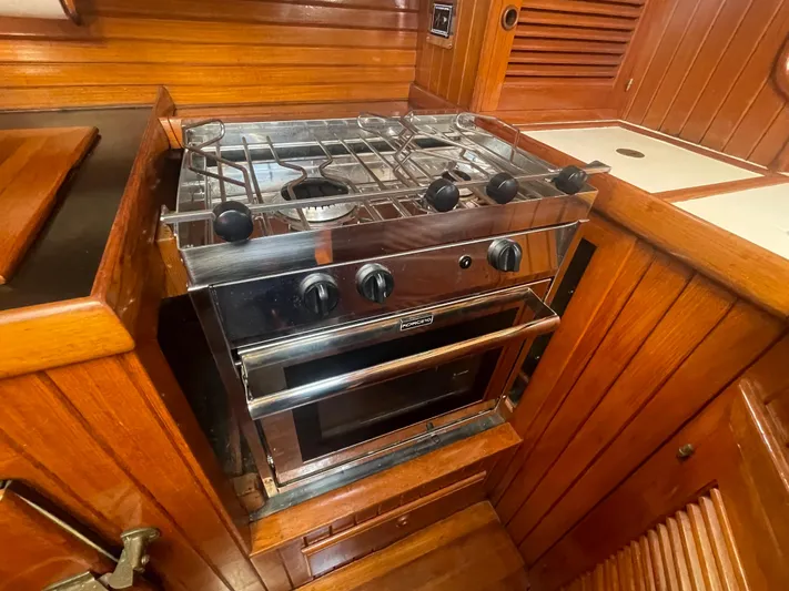 Mi Velero Yacht Photos Pics Stainless steel stove in 1985 Hans Christian 33T yacht galley, surrounded by rich wood paneling.