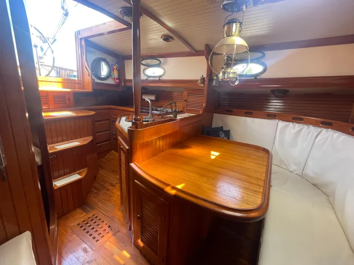 Mi Velero Yacht Photos Pics Interior of 1985 Hans Christian 33T sailboat with wooden furnishings and cozy seating area.