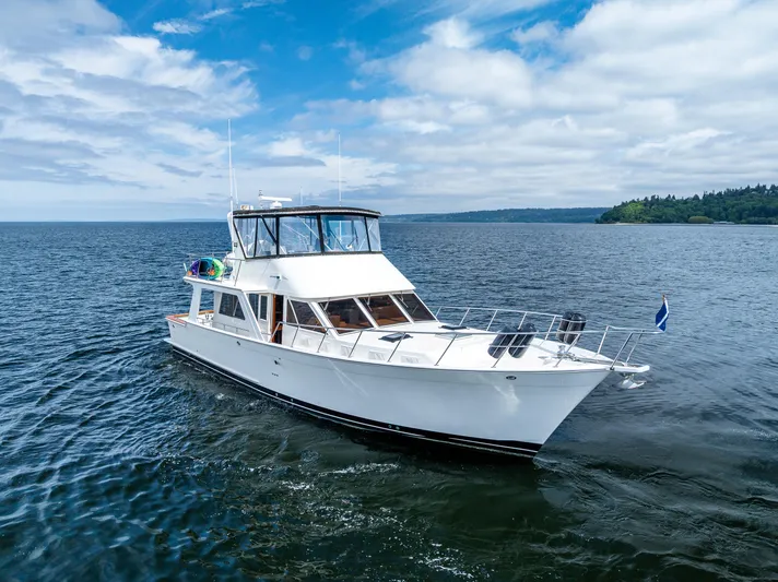 Am&eacute;lie Yacht Photos Pics Offshore Yachts 1997 52 Sedan cruising on open water under a partly cloudy sky.