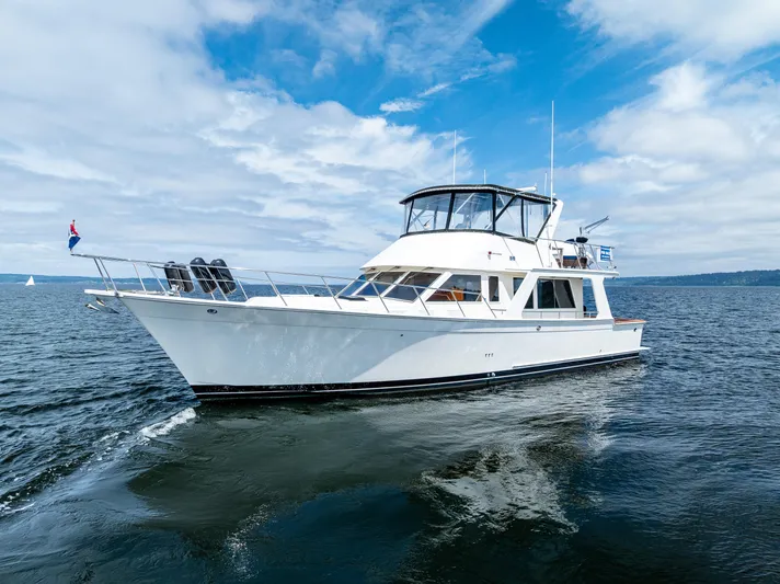 Am&eacute;lie Yacht Photos Pics 1997 Offshore Yachts 52 Sedan cruising on open water under a partly cloudy sky.