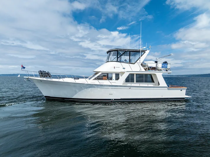 Am&eacute;lie Yacht Photos Pics Offshore Yachts 52 Sedan 1997 cruising on open water under a partly cloudy sky.