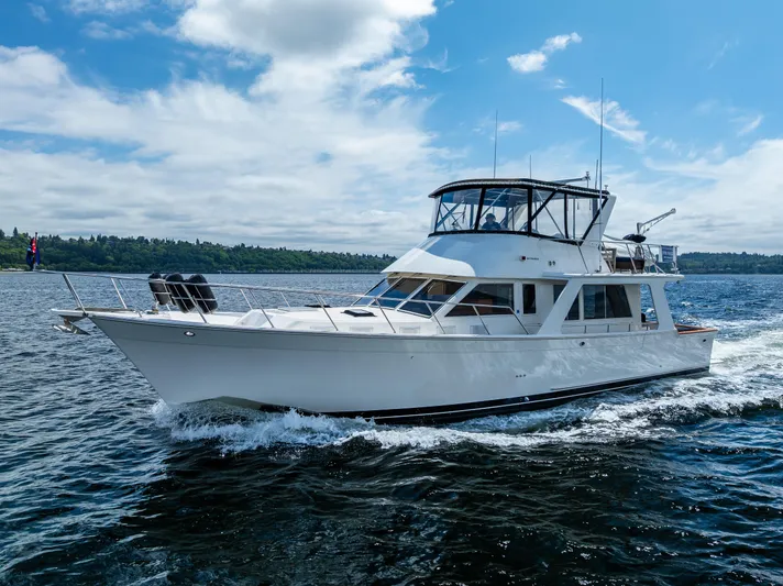 Am&eacute;lie Yacht Photos Pics Offshore Yachts 1997 52 Sedan cruising on open water under a partly cloudy sky.