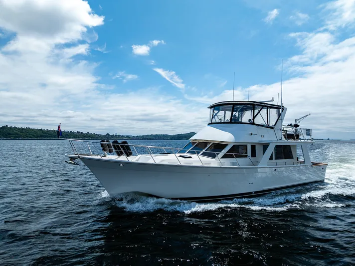 Am&eacute;lie Yacht Photos Pics Offshore Yachts 52 Sedan 1997 cruising on open water under a clear blue sky.