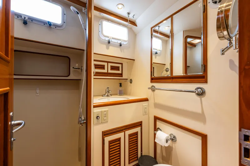 Am&eacute;lie Yacht Photos Pics Bathroom interior of 1997 Offshore Yachts 52 Sedan with wooden accents and mirrors.