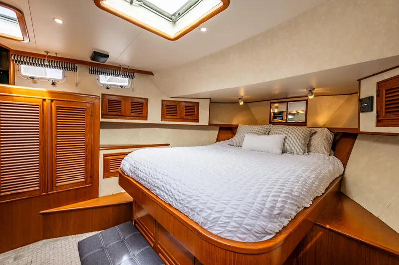 Am&eacute;lie Yacht Photos Pics Luxurious cabin interior of 1997 Offshore Yachts 52 Sedan with cozy bed and wooden accents.