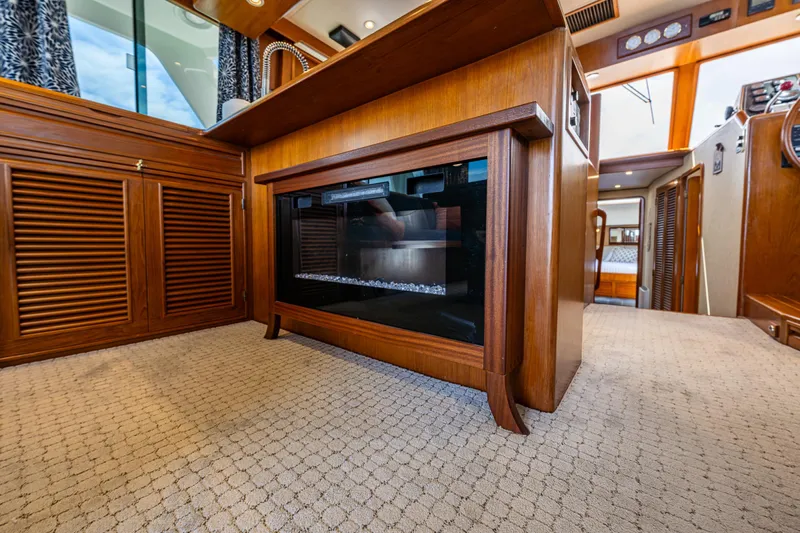 Am&eacute;lie Yacht Photos Pics Interior of 1997 Offshore Yachts 52 Sedan with wood cabinetry and modern fireplace.