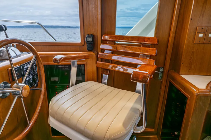Am&eacute;lie Yacht Photos Pics Captain's chair on 1997 Offshore Yachts 52 Sedan, featuring wood accents and ocean view.