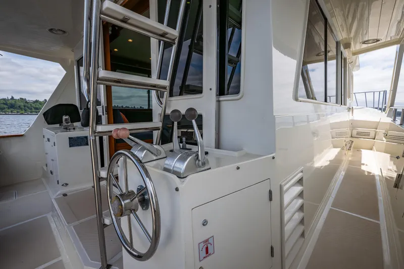 Am&eacute;lie Yacht Photos Pics 1997 Offshore Yachts 52 Sedan helm with steering wheel and controls, docked on a sunny day.