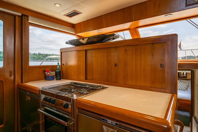 Am&eacute;lie Yacht Photos Pics Luxurious kitchen interior of 1997 Offshore Yachts 52 Sedan with wooden cabinetry and modern appliances.
