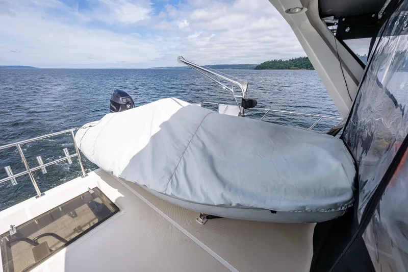 Am&eacute;lie Yacht Photos Pics 1997 Offshore Yachts 52 Sedan deck with covered equipment, overlooking serene ocean view.