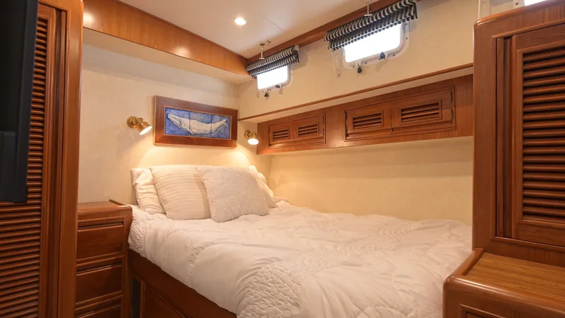 Am&eacute;lie Yacht Photos Pics Luxurious cabin interior of 1997 Offshore Yachts 52 Sedan with cozy bed and wooden accents.