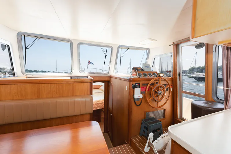  Yacht Photos Pics Interior of 2005 Mainship 400 Trawler with wooden helm and panoramic windows.