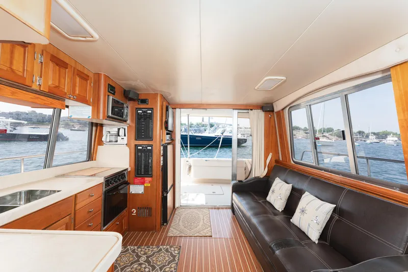  Yacht Photos Pics Interior of 2005 Mainship 400 Trawler with kitchen, sofa, and view of marina.