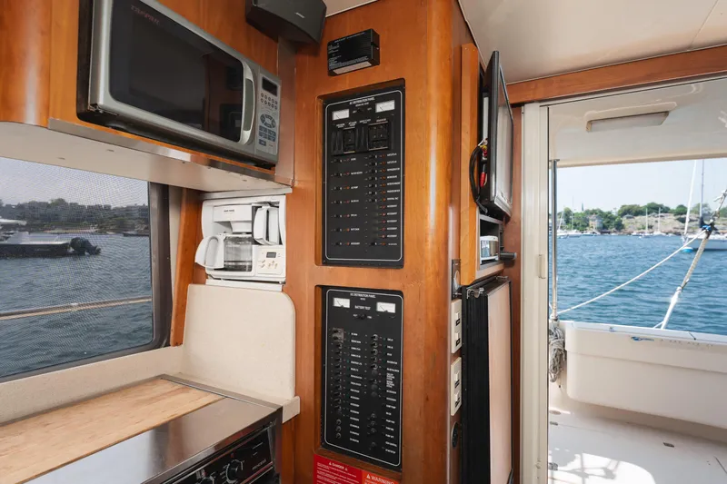  Yacht Photos Pics 2005 Mainship 400 Trawler interior with kitchen appliances and control panels, overlooking marina.