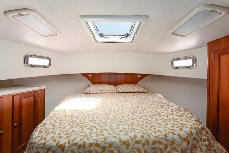  Yacht Photos Pics Cozy bedroom in 2005 Mainship 400 Trawler with skylight and wooden cabinetry.