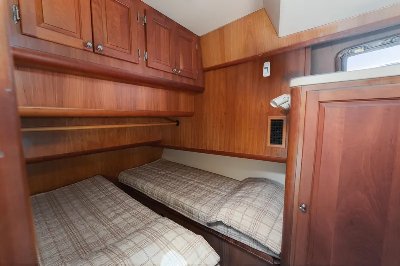  Yacht Photos Pics 2005 Mainship 400 Trawler cabin with twin beds and wooden cabinetry.