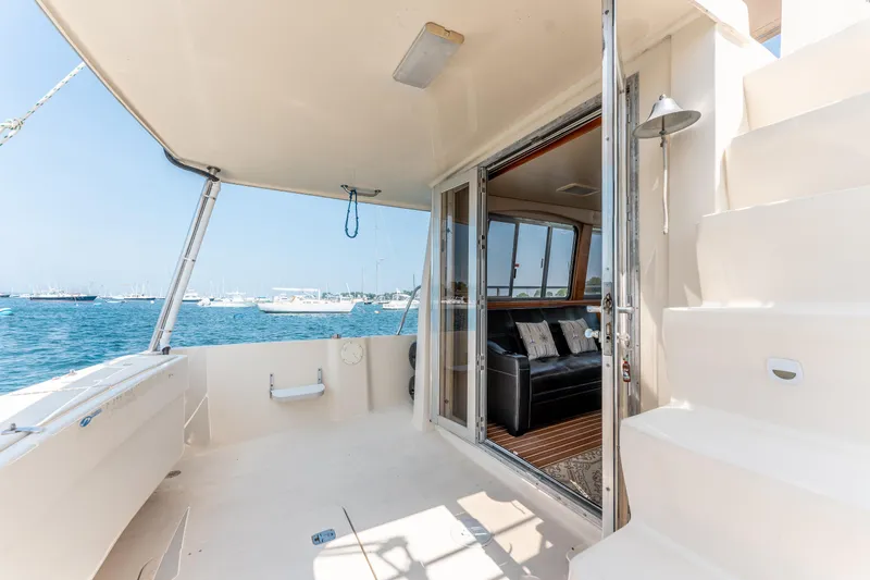  Yacht Photos Pics 2005 Mainship 400 Trawler interior view with open deck and ocean backdrop.