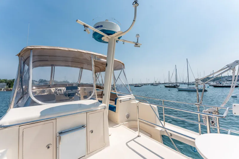  Yacht Photos Pics 2005 Mainship 400 Trawler on calm waters, surrounded by sailboats under clear skies.