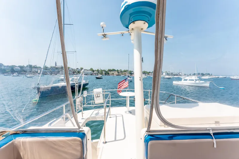  Yacht Photos Pics 2005 Mainship 400 Trawler on water, scenic harbor view, clear sky.