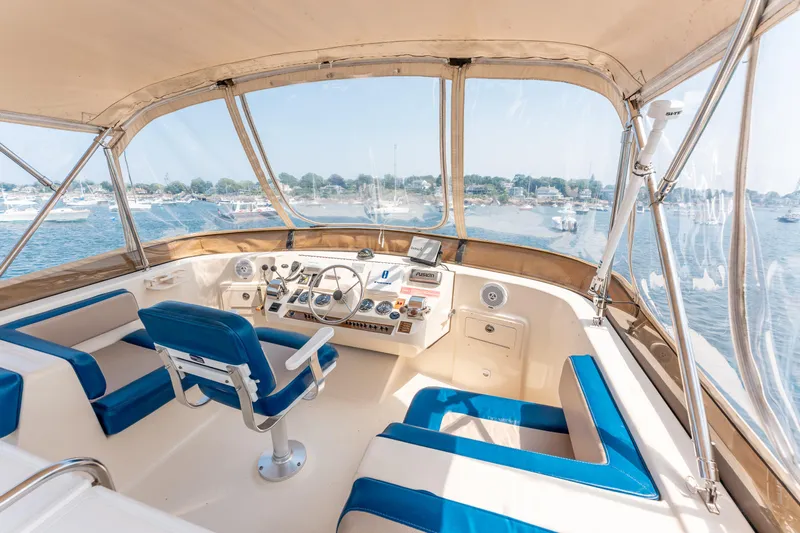 Yacht Photos Pics 2005 Mainship 400 Trawler helm with blue seating, overlooking a scenic marina.