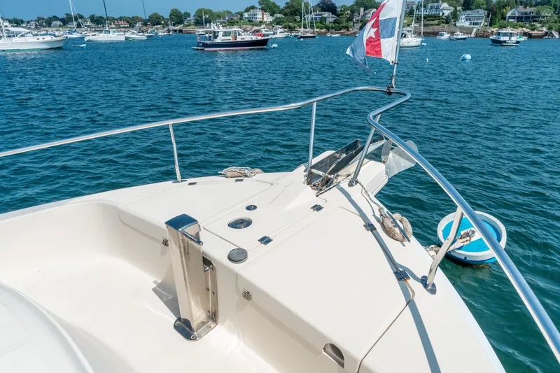  Yacht Photos Pics 2005 Mainship 400 Trawler bow view, anchored in a scenic harbor with boats.