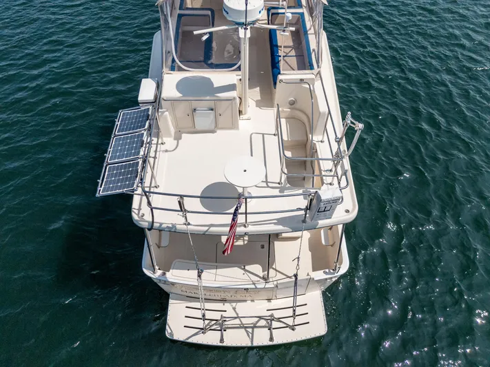  Yacht Photos Pics 2005 Mainship 400 Trawler on water, aerial view, featuring solar panels and American flag.