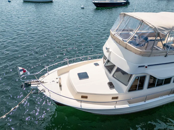  Yacht Photos Pics 2005 Mainship 400 Trawler on calm water, featuring a spacious deck and flybridge.