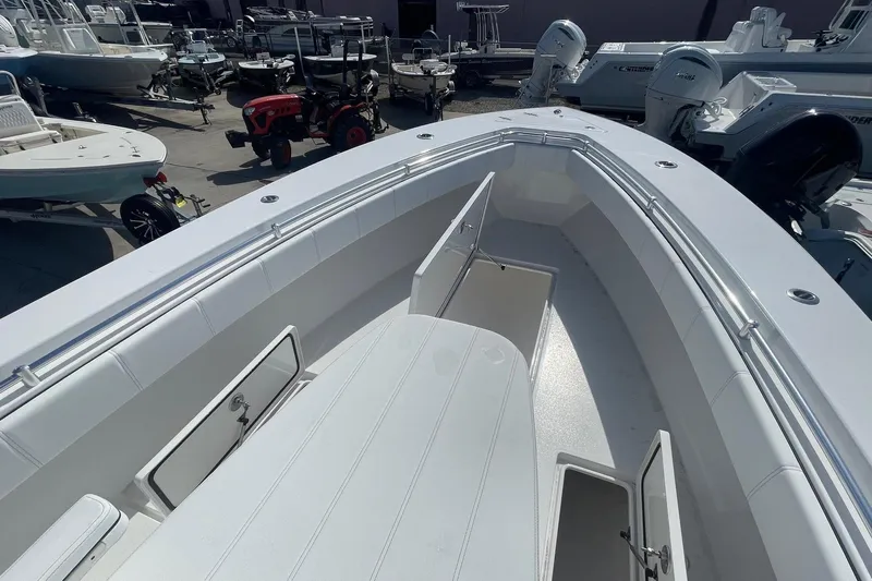  Yacht Photos Pics 2026 Contender 32 ST boat with open storage compartments, docked among other vessels.