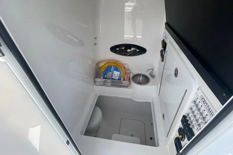  Yacht Photos Pics Interior of 2026 Contender 32 ST boat featuring compact bathroom with sink and storage.