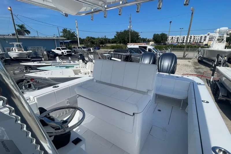  Yacht Photos Pics 2026 Contender 32 ST boat with dual engines, white seating, and steering wheel in a marina setting.