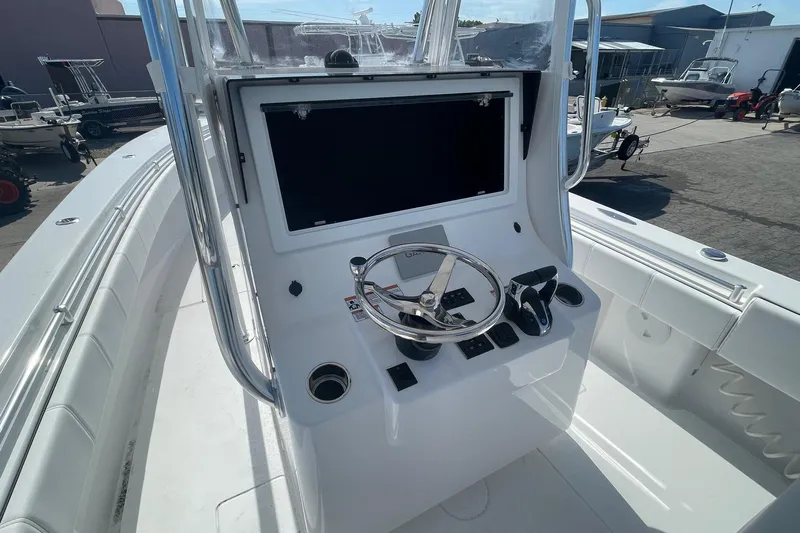 Yacht Photos Pics 2026 Contender 32 ST boat console with steering wheel and controls in a marina setting.