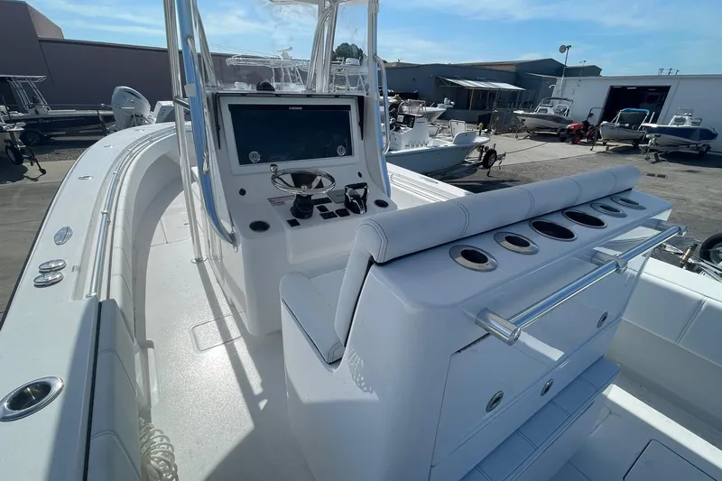  Yacht Photos Pics 2026 Contender 32 ST boat interior with helm, seating, and rod holders in a marina setting.
