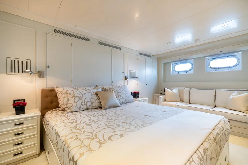 Anonymous Yacht Photos Pics Luxurious yacht bedroom with elegant decor, featuring a plush bed and cozy seating area.