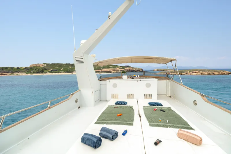 Anonymous Yacht Photos Pics Luxurious 1981 Hellenic Shipyards custom yacht deck with sunbeds, towels, and ocean view.