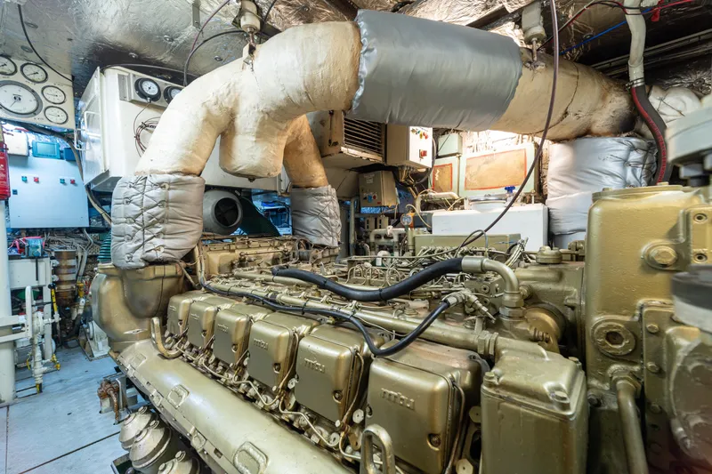 Anonymous Yacht Photos Pics Engine room of 1981 Hellenic Shipyards custom vessel, featuring complex machinery and piping.