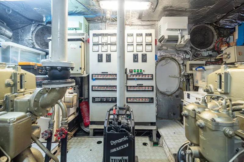 Anonymous Yacht Photos Pics Engine room of 1981 Hellenic Shipyards custom vessel, featuring control panels and machinery.